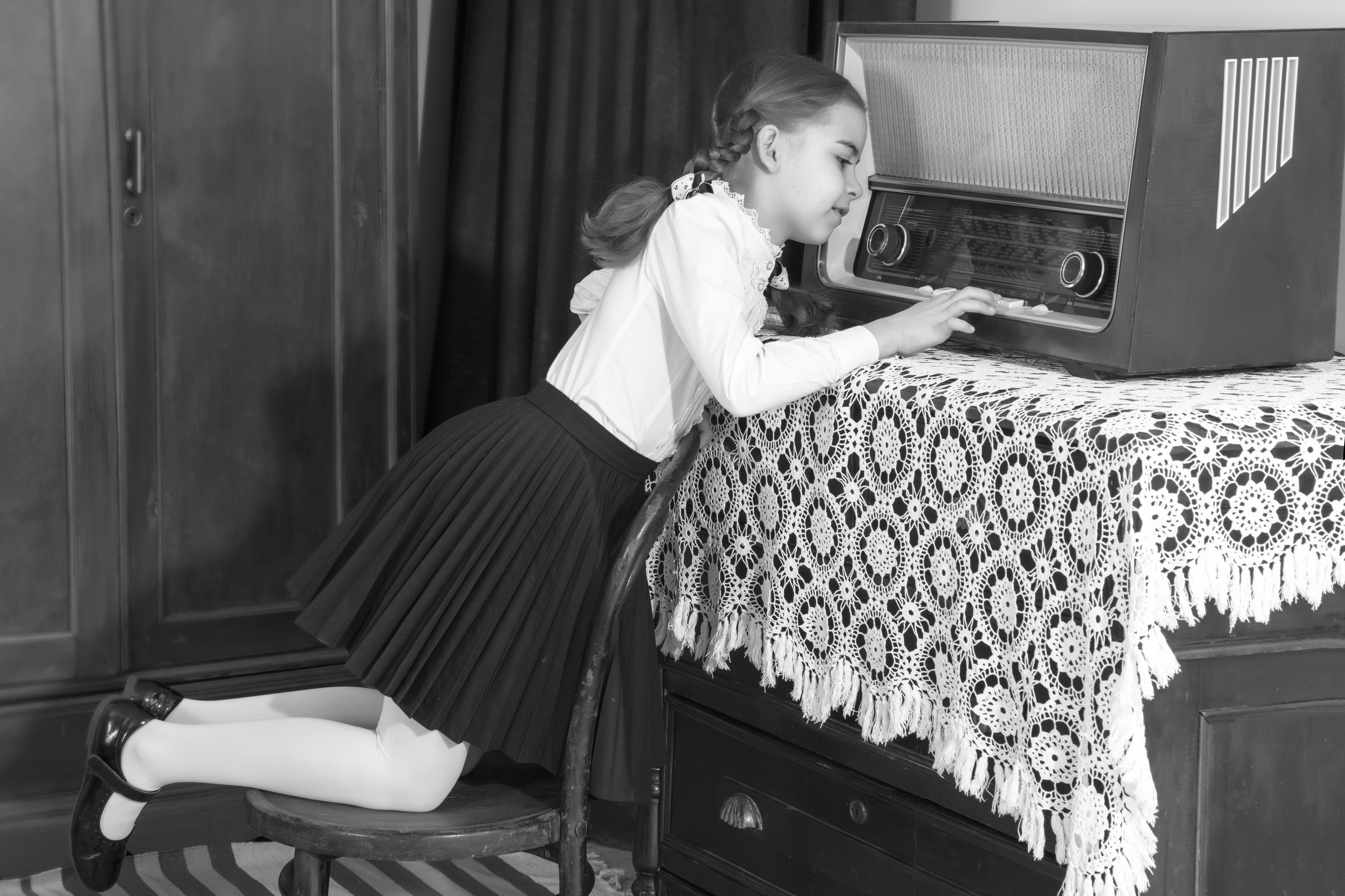 Black and white picture of a child playing with a radio