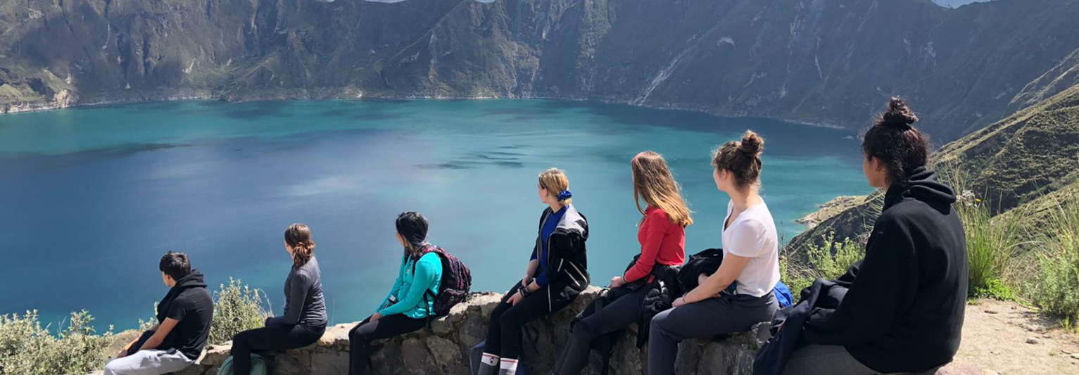 Students looking out to a beautiful blue lake in Ecuador