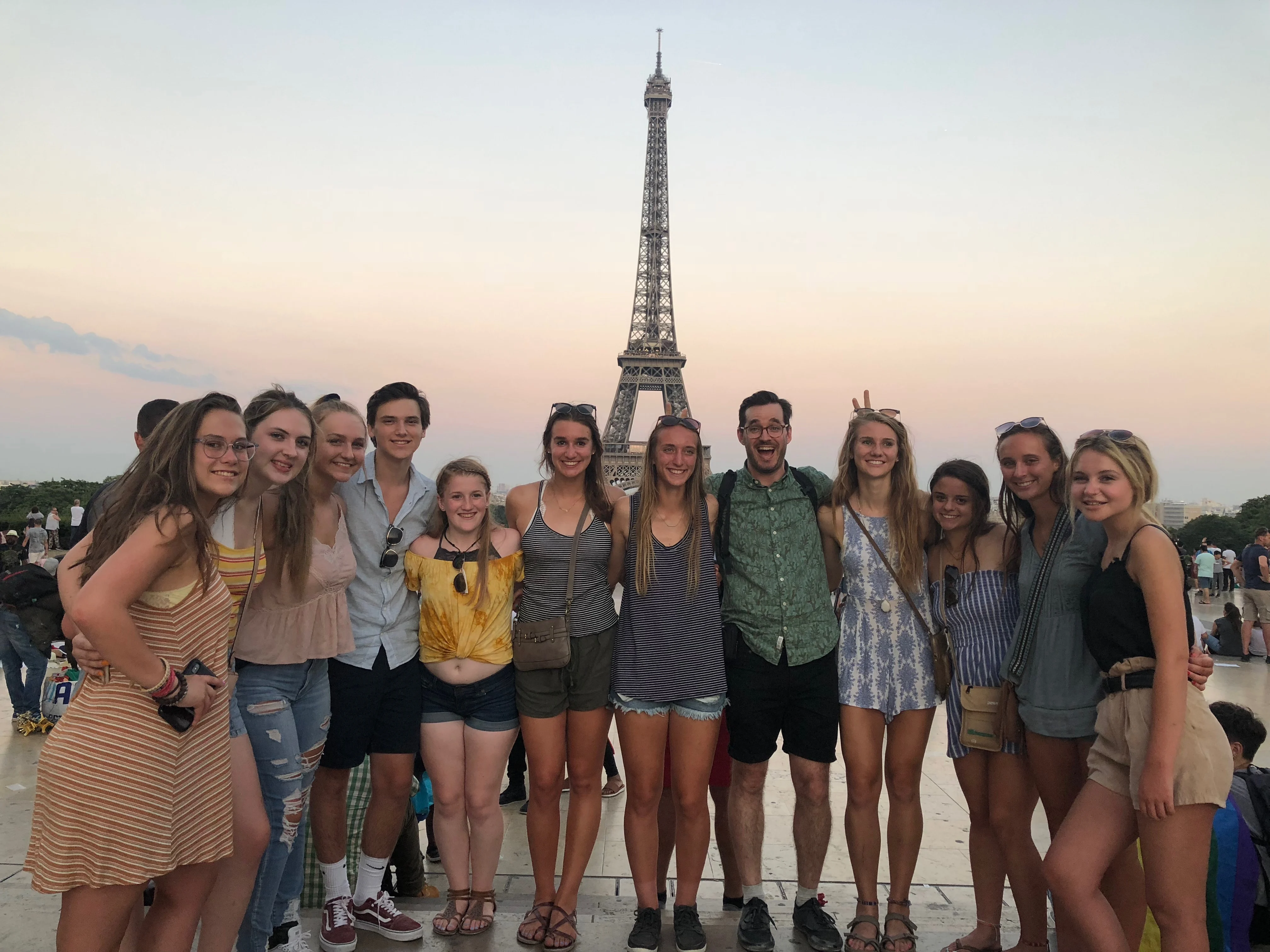 Group of students striking a pose in front of the Eiffel Tower