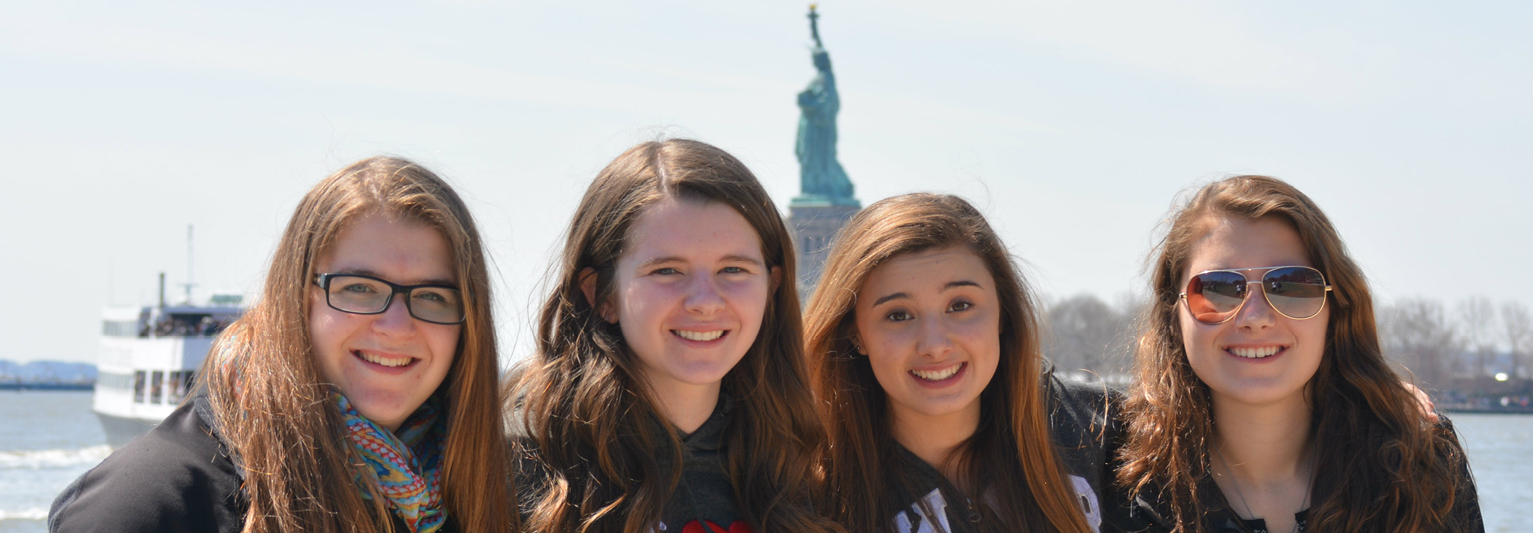 Smiling students in front of Liberty Statue